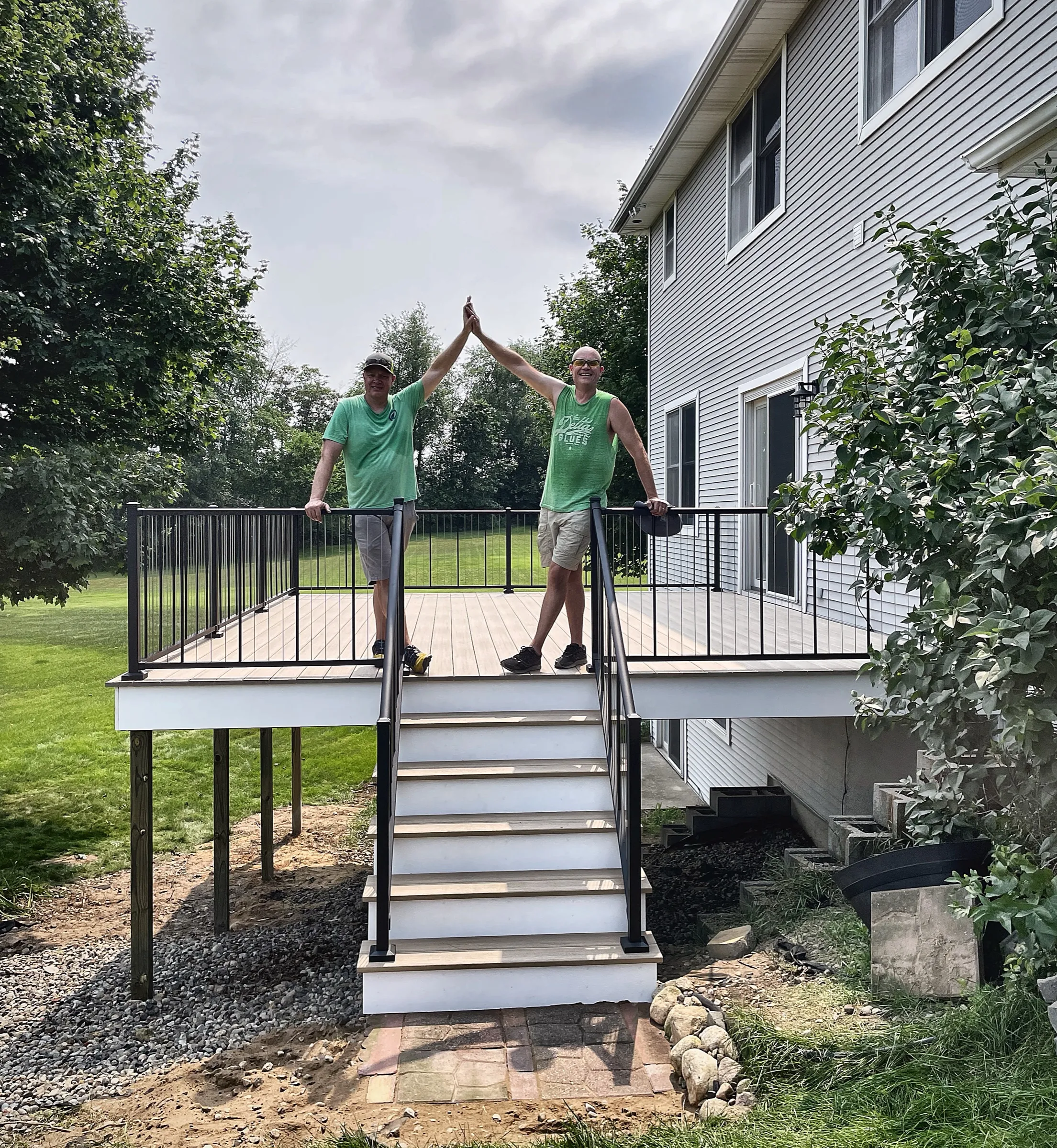 Todd and Randen Kroes high-fiving on a freshly finished composite deck